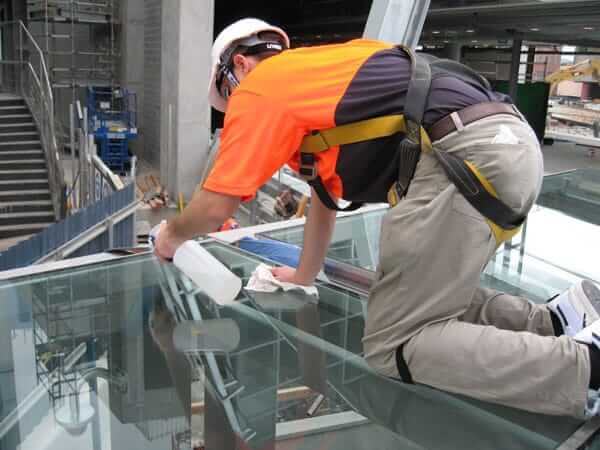 man applying hydrophobic coating to glass roof